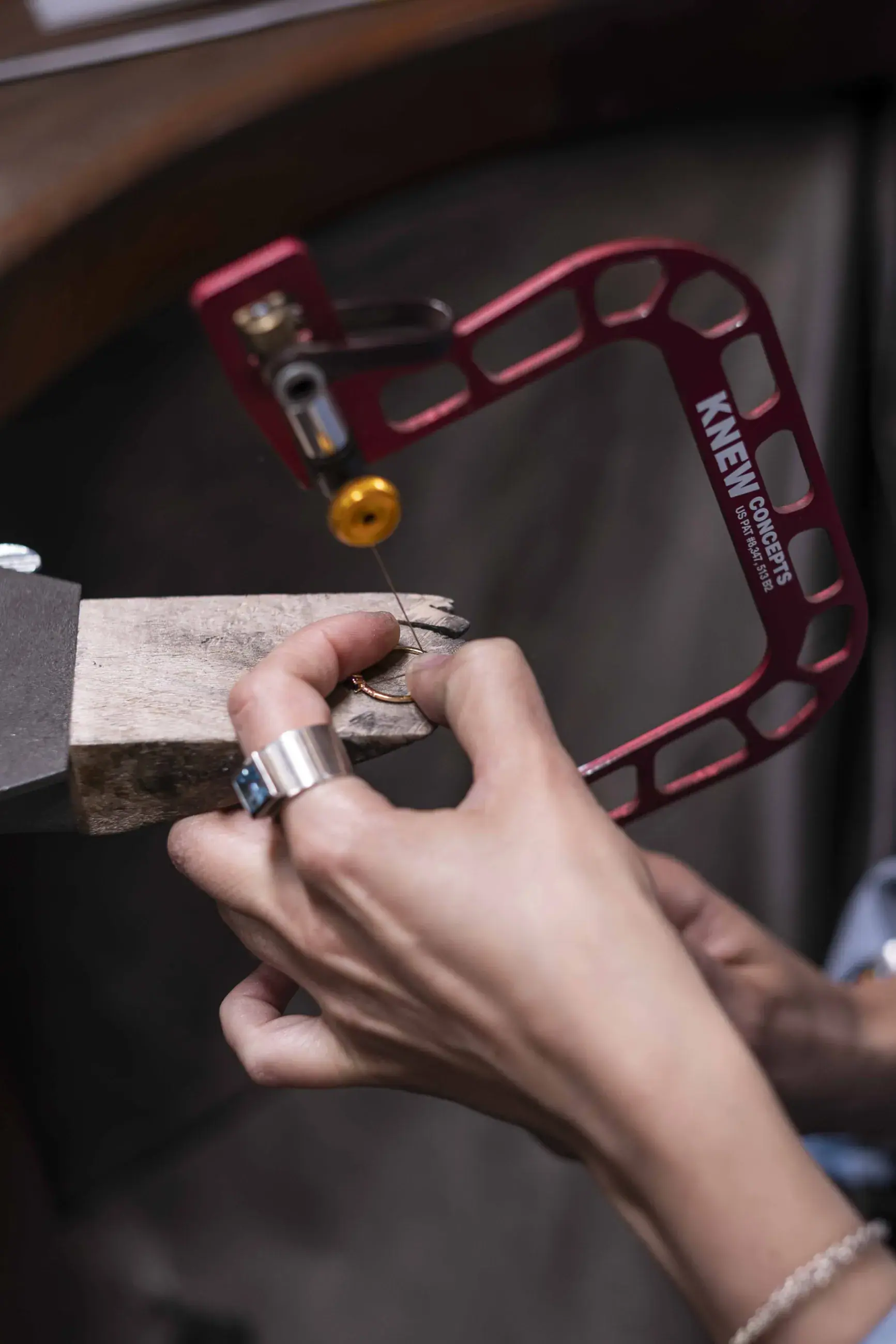 Hände sägen mit der Laubsäge an einem Ring