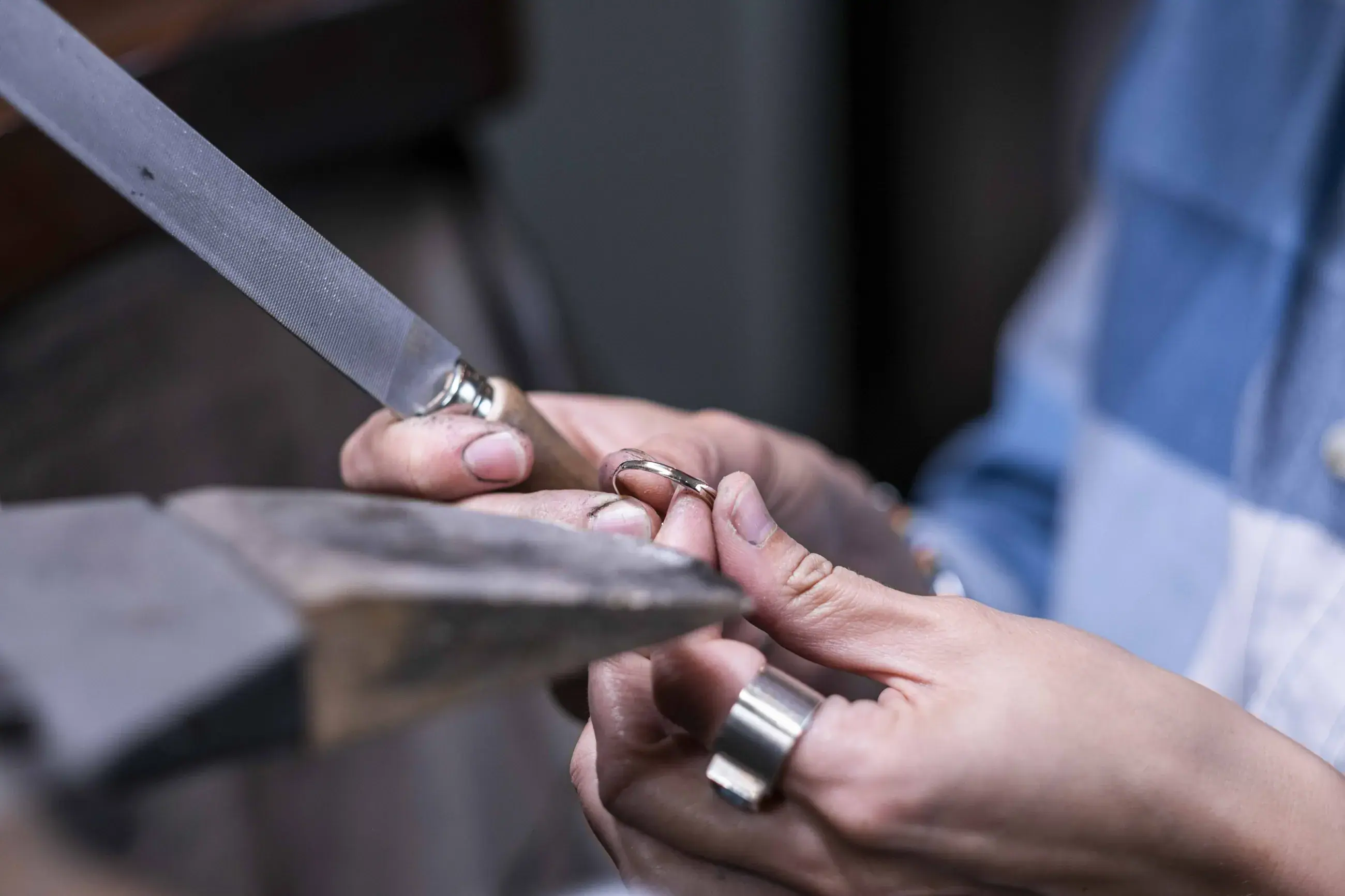 Hände feilen einen Ring in der Werkstatt